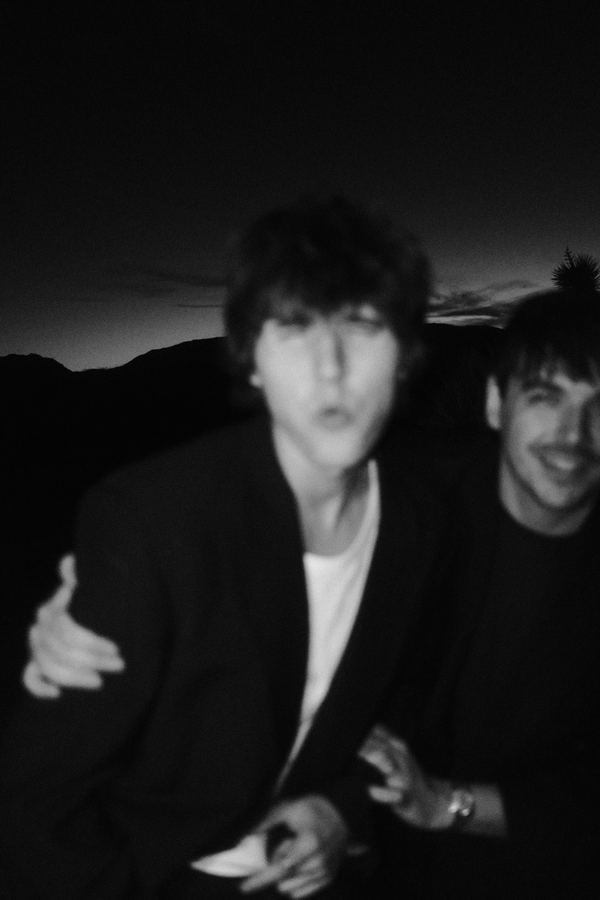 Blurry black and white snapshot of the two band members laughing at night